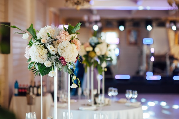 Un beau vase de fleurs sur une table dans un restaurant de luxe. Décorations de mariage.