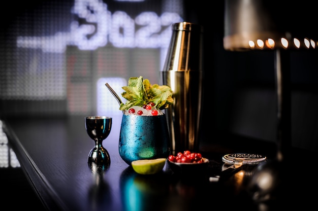 Beau verre à cocktail bleu avec cocktail d'été décoré de fruits