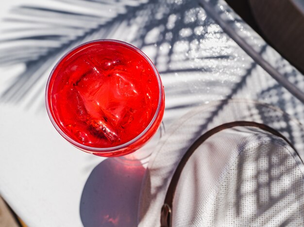 Beau verre avec un cocktail rose et de la glace