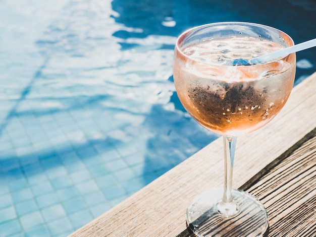 Beau verre avec un cocktail rose et des glaçons