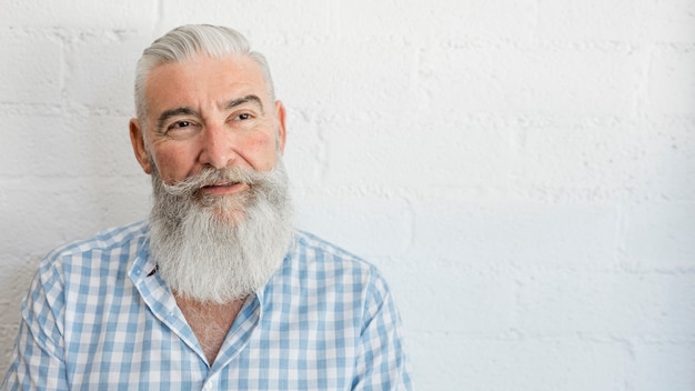 Beau vieillard barbu en chemise en studio