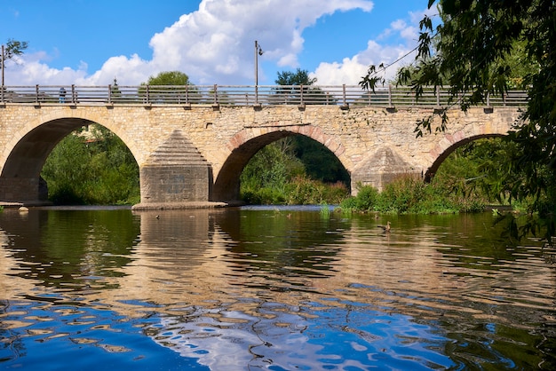 Photo beau vieux pont sur une rivière calme par une journée ensoleillée