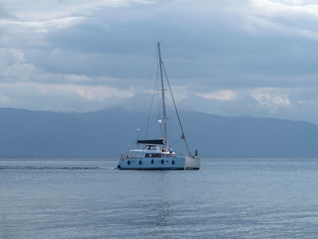 Beau Yacht-catamaran Un Jour Nuageux Sur La Mer égée Calme Sur L'île D'evia, Grèce