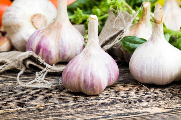 Beaucoup d'ail sur la planche à découper pendant la cuisson, table de cuisine pendant la cuisson des aliments, gros plan