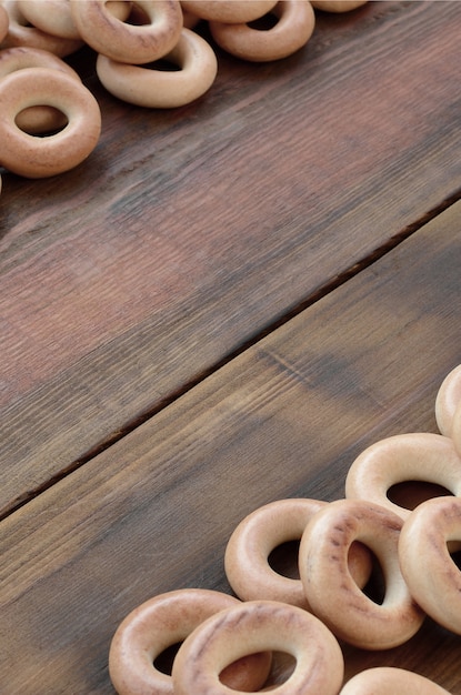 Beaucoup de bagels jaunes frais se trouvent à la surface du vieux bois sombre