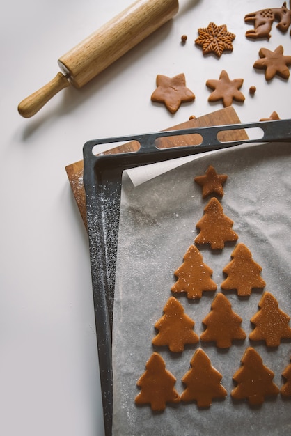 Beaucoup de biscuits de pain d'épice sont disposés en forme d'arbre de Noël sur parchemin