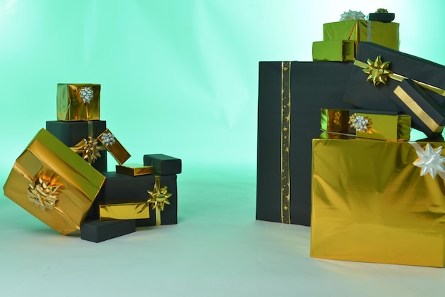 Photo beaucoup de boîtes à cadeaux en noir et or sur un fond vert