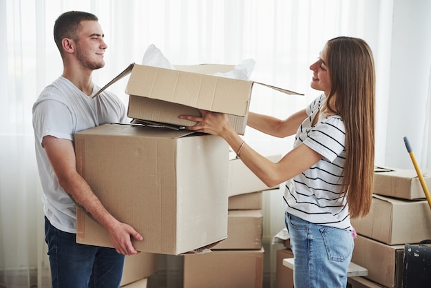 Beaucoup de boîtes. Joyeux jeune couple dans leur nouvel appartement. Conception du déménagement.