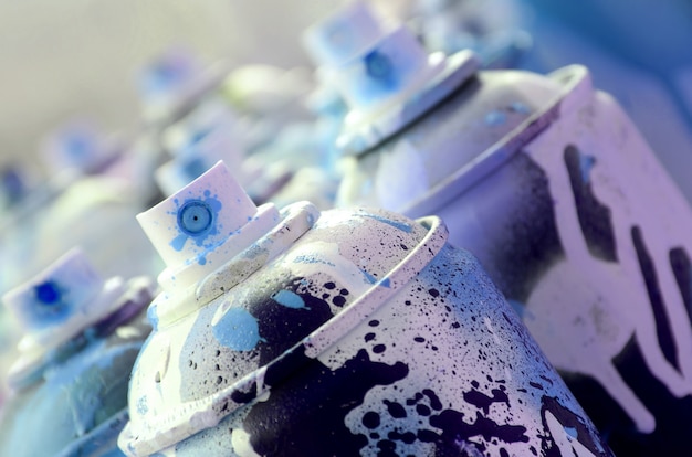 Beaucoup de bombes aérosols sales et usagées de peinture bleu vif.