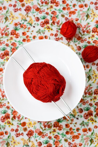 Beaucoup de boules lumineuses de tricot sur le fond d'une fleur rouge