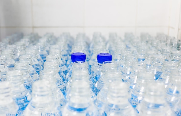 Beaucoup de bouteilles d'eau avec bouchons bleus Usine d'embouteillage Ligne d'embouteillage d'eau pour le traitement