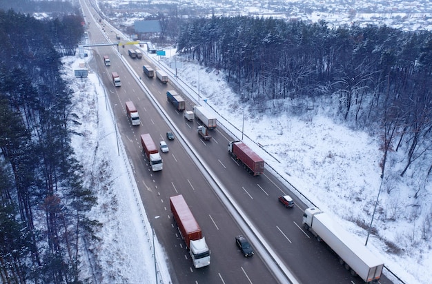 Beaucoup de camions sur l'autoroute Paysage industriel d'hiver Vue de drone