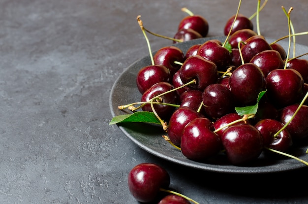 Beaucoup de cerises mûres sur une plaque noire