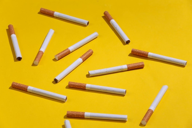 Beaucoup de cigarettes sur fond clair jaune.