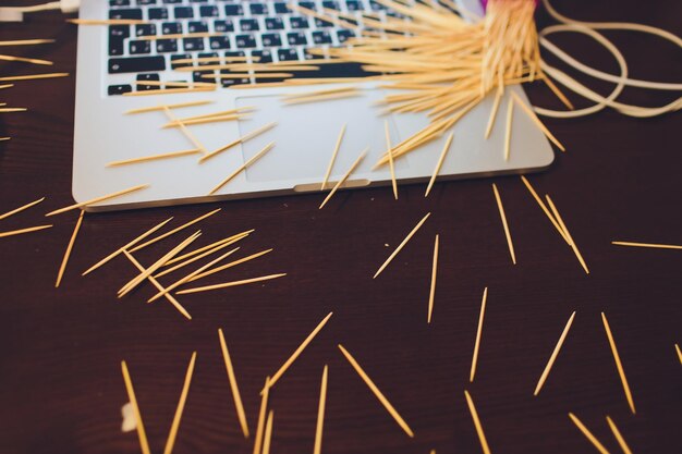 beaucoup de cure-dents en bois sur le fond de la table brune un ordinateur portable