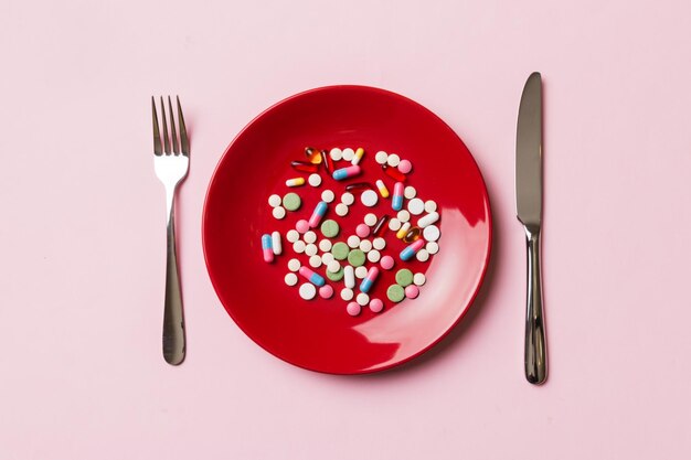 Beaucoup de différentes pilules et suppléments de perte de poids comme nourriture sur une assiette ronde Pilules servies comme repas sain Médicaments pharmacie médecine ou concept médical de soins de santé
