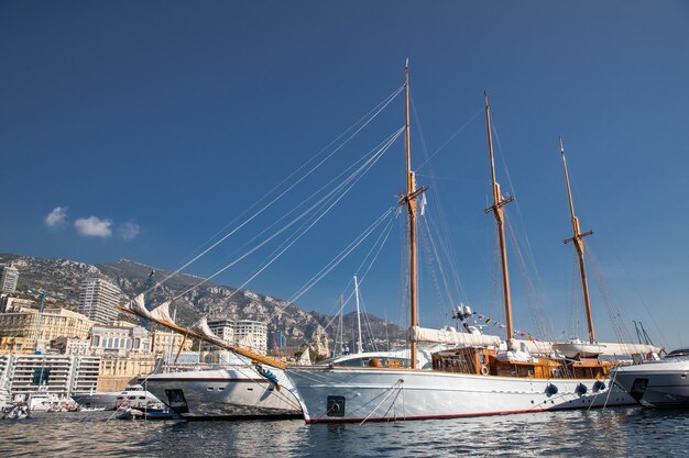 Beaucoup d'énormes yachts sont dans le port de monaco lors d'une journée ensoleillée la montagne de monte-carlo est en arrière-plan big ma ...