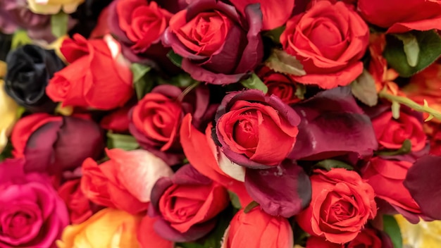 Beaucoup de fausses fleurs roses rouges artificielles fausses plantes faites de tissu au magasin simulant la réalité et la nature concept abstrait simple superficiel dof éléments décoratifs personne Imitation de vraies plantes