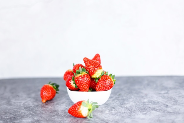 Beaucoup de fraises rouges fraîches sur fond sombre. Baies rouges saines pleines de vitamines