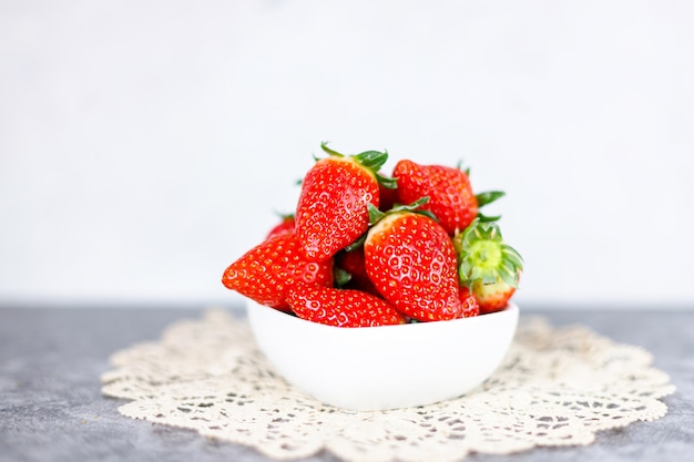 Beaucoup de fraises rouges fraîches sur une surface sombre. Baies rouges saines pleines de vitamines