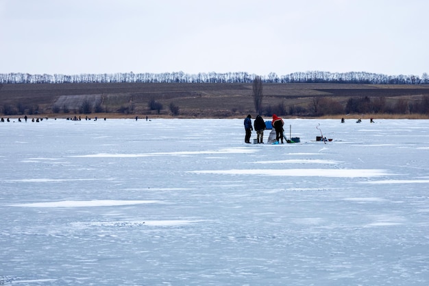 Beaucoup de gens sur la glace hiver pêche rivière gelée en hiver pêche sur glace