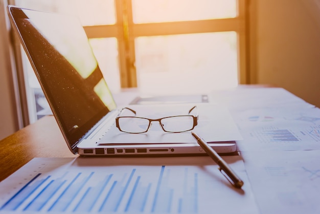 Photo beaucoup de graphiques et de lunettes. revoir les données rapports financiers et lunettes. fond de réflexion.