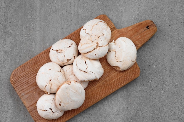 Beaucoup de meringue sur une planche à découper en bois Meringue de cacao Meringue sur fond gris