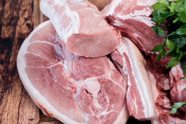 Photo beaucoup de morceaux de viande de porc fraîche sur une planche à couper en bois