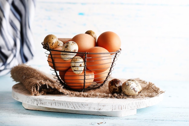 Beaucoup d'oeufs dans le panier sur fond de bois