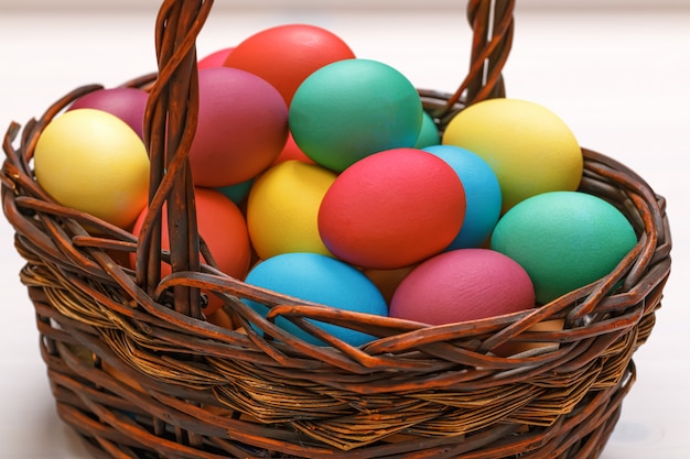 Beaucoup d'oeufs de Pâques colorés dans le panier.