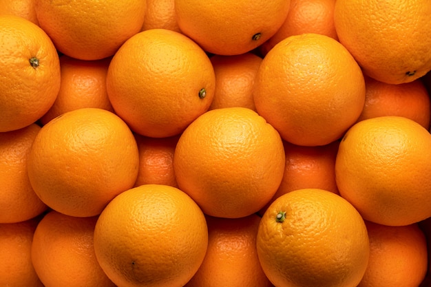 Beaucoup d'oranges mûres, soigneusement rangées. Vue de dessus, gros plan