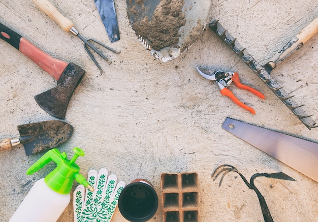 Beaucoup d'outils de jardin utilisés et sales sur le sol en béton à l'extérieur