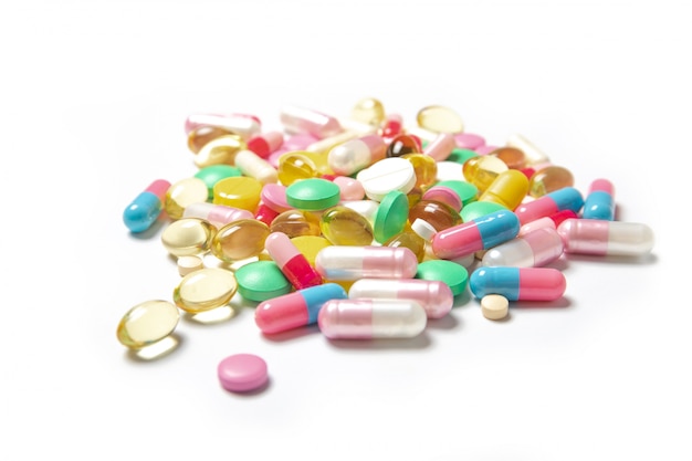Beaucoup de pilules colorées sur fond blanc