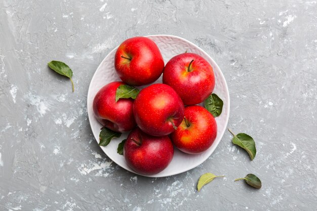 Beaucoup de pommes rouges sur fond de ciment, vue de dessus. Modèle d'automne avec vue ci-dessus pomme fraîche