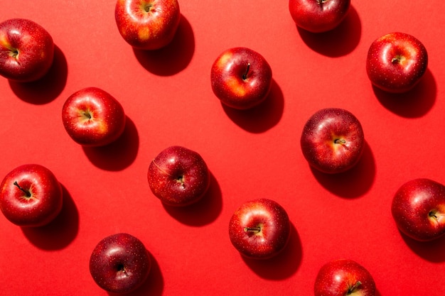 Beaucoup de pommes rouges sur fond coloré, vue de dessus. Modèle d'automne avec vue ci-dessus pomme fraîche