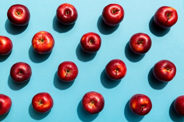 Beaucoup de pommes rouges sur fond coloré, vue de dessus. Modèle d'automne avec vue ci-dessus pomme fraîche