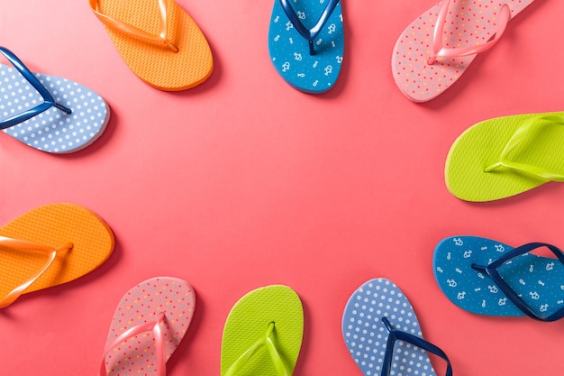 Beaucoup de sandales colorées à bascule, vacances d'été sur fond coloré, vue de dessus de l'espace de copie.