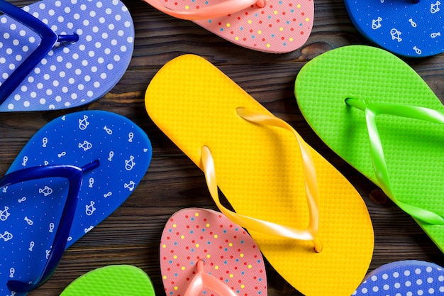 Beaucoup de sandales de couleur flip flop, vacances d'été sur fond en bois, copie espace vue de dessus