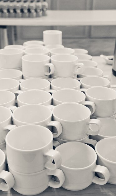 Beaucoup de tasses en porcelaine blanche vides sur la table