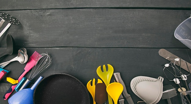 Beaucoup d'ustensiles de cuisine différents sur la table en bois