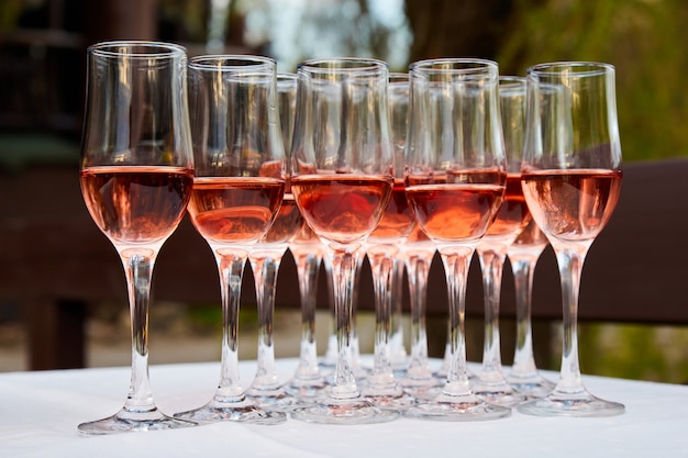 Beaucoup de verres à vin rosé pour les invités à la table du buffet