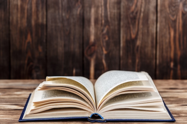 Beaucoup de vieux livres sur fond en bois. La source d'information. Livre ouvert à l'intérieur. Bibliothèque d'accueil. La connaissance est le pouvoir