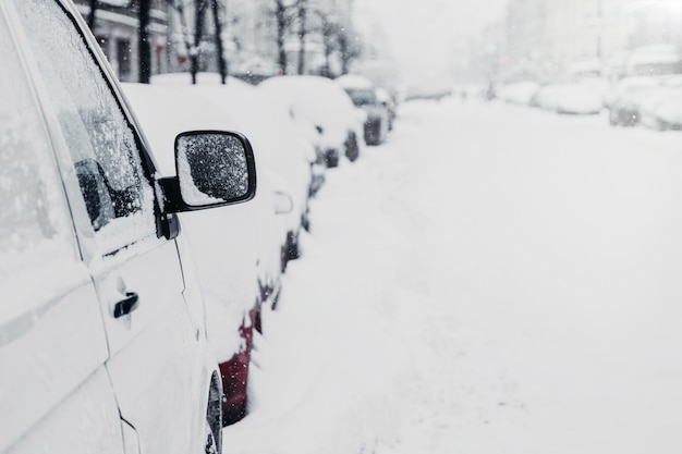 Beaucoup de voitures sur la route d'hiver ou dans le parking Ville enneigée Chutes de neige en hiver Circulation et mauvaises conditions météorologiques Paysage urbain Voitures coincées dans la neige