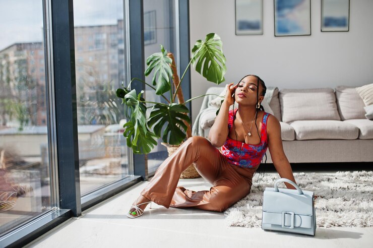 Photo beauté afro-américaine modèle mode femme brésilienne pose intérieure avec sac à main.