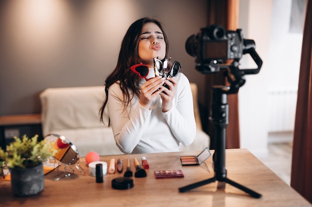Beauté blogueuse douce femme filmant tutoriel de routine de maquillage quotidien à la caméra.