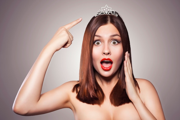 Beauté bouchent le portrait d'une femme brune avec du rouge à lèvres rouge. Diadème de couronne de diadème sur elle.