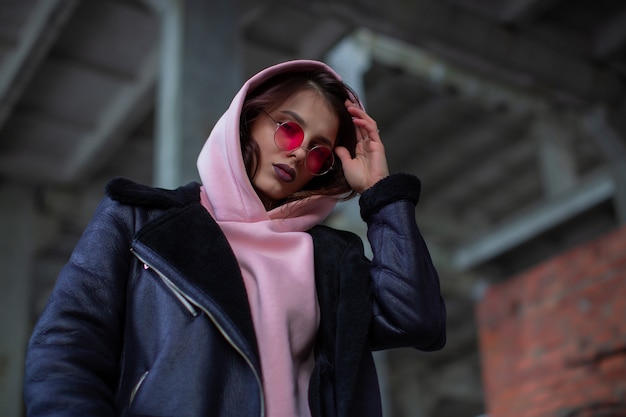 Une beauté cool avec un sweat à capuche poudré et une veste en cuir