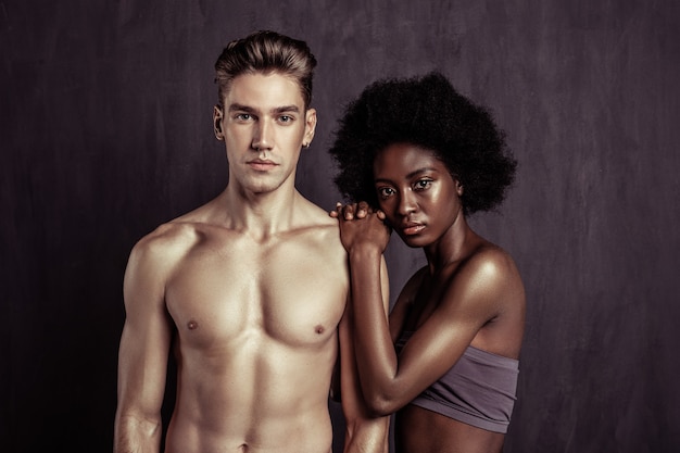 Photo la beauté dans la différence. sérieux couple attrayant regardant devant eux tout en posant pour une photo