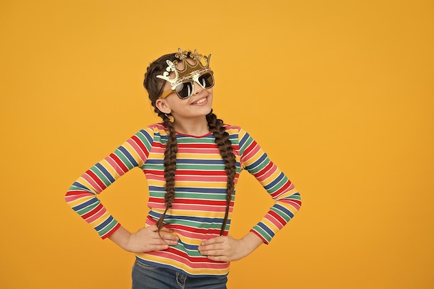 Beauté égoïste Une fille heureuse porte une couronne et des lunettes d'accessoires Regard de beauté d'un petit enfant Concours de beauté Salon de beauté Soins de la peau Soins des cheveux Accessoires de fête de mode Se sentir comme un espace de copie royal