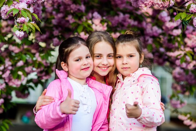 Beauté de l'enfance d'été Jour de la famille Allergie à l'odeur des fleurs Fraternité soeurs heureuses en fleur de cerisier Sakura en fleurs Cosmétiques naturels pour la peau petite fille enfants au printemps fleur fleurie